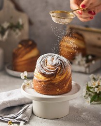 happy easter. traditional easter cake , homemade kraffin with raisins,candied fruits .cherry blossom on white beton background.selective focus.close up of homemade cruffin.