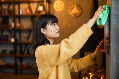 side view portrait of young asian woman cleaning home apartment, copy space