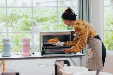 young asian female baking croissant bread preparing breakfast, food and cuisine concept