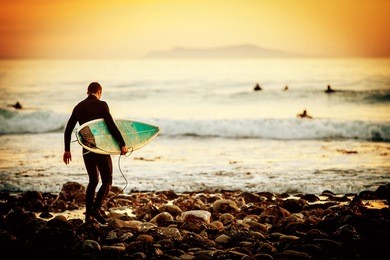 surfer on the beach at sunset