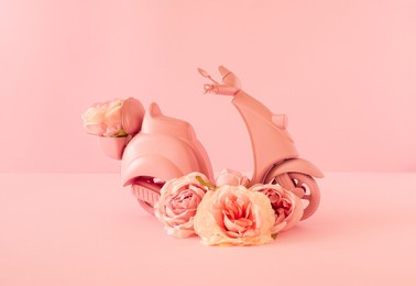creative composition of scooter and rose flowers on pastel background. pink romantic concept. minimal valentines day, wedding or mother's day concept. creative spring or summer floral layout.