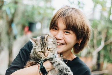 close up of young asian woman playing with her persian cat, human-animal relationships.