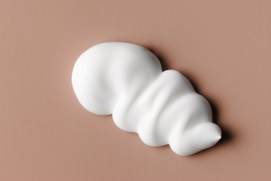 white cream texture. cosmetic creamy product on brown background. sunscreen, face creme, body lotion, hair conditioner swirl swatch closeup