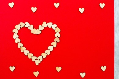 valentines day background with wooden hearts. little wood hearts on a red background. romantic mood. beautiful background.  space for text. copy space. flat lay, top view