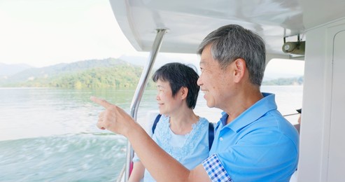 authentic shot of asian elderly couple have fun on boat