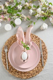 easter dinner with white bunny, fresh spring flowers and eggs. elegance pastel and pink tablescapes. view from above. christian religion tradition. vertical.