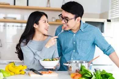 image of newlywed couple cooking at home