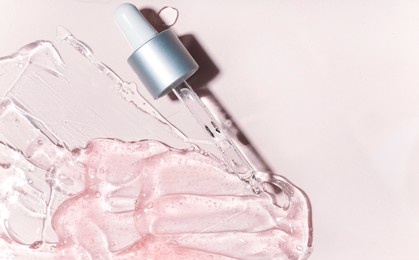 drops of facial serum with pipette on glass