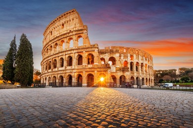 rome, italy at the colosseum amphitheater with the sunrise through the entranceway. 