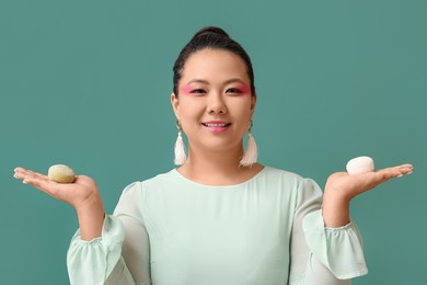 beautiful asian woman with tasty japanese mochi on color background