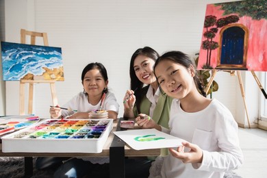 cute asian girl learning and studying drawing water color in a white classroom with lovely teacher. concentration training and brain development of learners. education concept