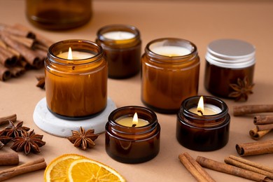 a set of different aroma candles in brown glass jars. scented handmade candle. soy candles are burning in a jar. aromatherapy and relax in spa and home.