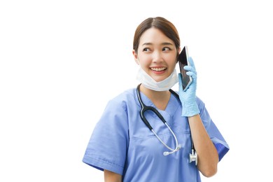 young asian woman doctor nurse wearing a surgical mask on her chin looking sideways to copyspace giving consult and instruction and diagnose the patient health problem though healthcare phone service.