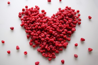 fresh raspberries in the shape of a heart on a white background