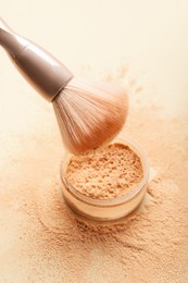 makeup brush and loose powder on light background