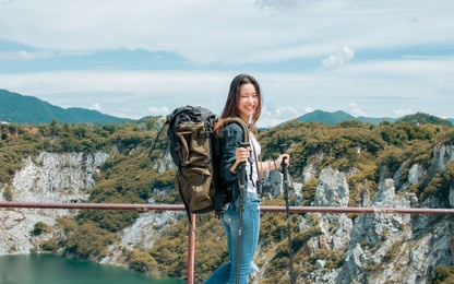 asian beautiful woman wearing hat and casual clothes, smiling with happiness, adventure traveling alone and hiking on the top of mountains with backpack in summer vacation trip on weekend