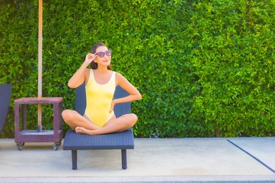 portrait beautiful young asian woman relax smile enjoy leisure around swimming pool in resort hotel on vacation