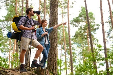 happy couple going on a hike together in a forest