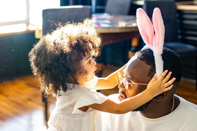 authentic ethnic multicultural people wearing bunny ears in living room day sunlight