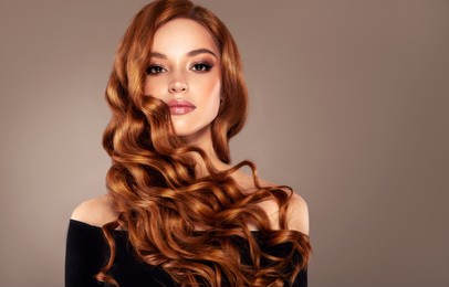 redhead  girl with long  and   shiny wavy red hair .  beautiful  model with curly hairstyle