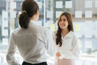 smiling hr manager shaking hand of successful candidate after interview, asian woman getting job, diverse business partners handshake, making great deal, agreement, employer greeting new employee.
