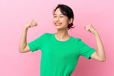 young vietnamese woman isolated on pink background doing strong gesture