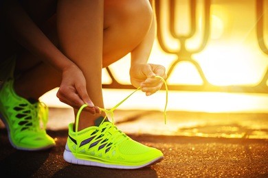 running shoes. barefoot running shoes closeup. female athlete tying laces for jogging on road in minimalistic barefoot running shoes. runner getting ready for training. sport lifestyle.