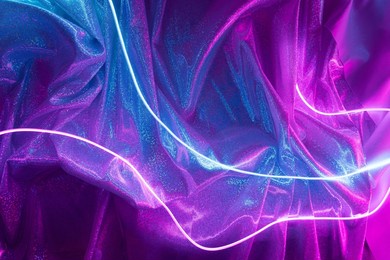 pink and blue neon lights with glitter fabric background. cyberpunk futuristic template.
