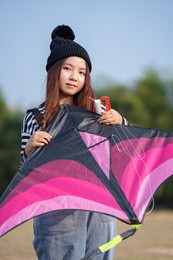young woman playing kite at the grass field. asian girl flying a kite in summer