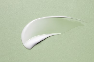 white cosmetic cream texture, skincare lotion swatch on green. face creme, body moisturiser, hair conditioner smear smudge stroke on color background. creamy beauty product closeup