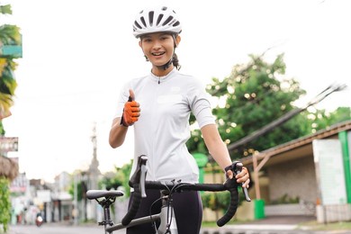 beautiful asian road bike cyclist showing thumb up