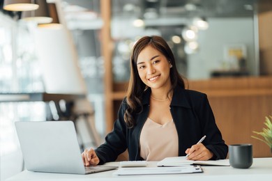 portrait of an asian young business female working on a laptop computer in her workstation.business people employee freelance online report marketing e-commerce telemarketing concept.