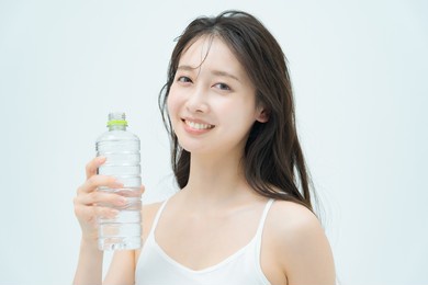 woman drinking water from a plastic bottle