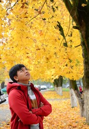young asian man enjoying autumn scenery in moscow, russia.