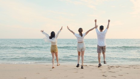 happy friends holding hands running enjoy life funny and freedom on sand at beach together to sea in holiday vacation time at sunset, young asian group woman and man in summer travel, people lifestyle