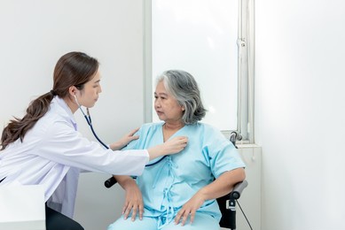 an asian doctor woman using a stethoscope listen to heart rate of elderly woman patients to check for heart disease, to annual health check of the elderly concept.