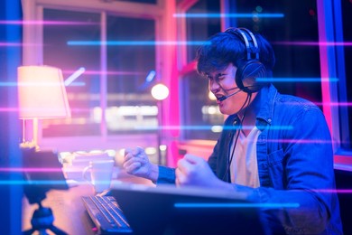 esport online game streaming asian male wear headset play dogital metaverse cyber space online match compettition sport game battle night time,young asia male enjoy exited gamer successful celebration