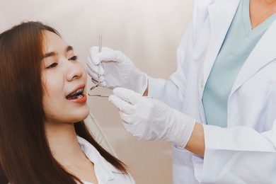 female dentist using oral examination of asian women with orthodontics has undergone dental checkups by professional dentists in state-of-the-art clinics.