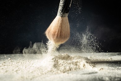 cosmetic brush and spray powder powder on a dark background