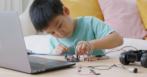 asia people home school young small kid happy smile laugh self study online lesson excited make ai circuit toy. stem steam digital class on laptop for active children play arduino enjoy fun hobby.