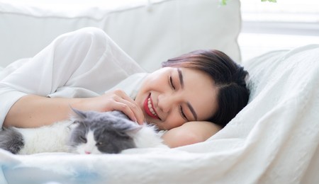 young asian woman playing with cat at home