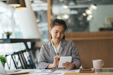 beautiful cute asian young businesswoman in the cafe, using caculator