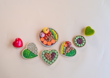 organic  healthy  food , herbal  medicine  capsules in  wooden  bowls  and  two  hearts  shape  on pastel  background for  the  health  concept
