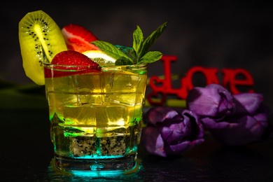 cocktail with ice and fresh mint and fresh fruits on a dark background.