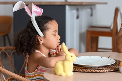 little african-american girl praying at table in kitchen on easter day
