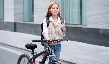 young asian woman using bicycle as a means of transportation
