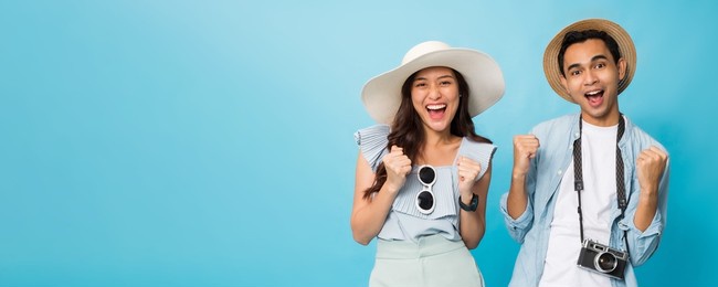 asian happy young couple tourist preparing for travel with copy space isolated on blue banner background.