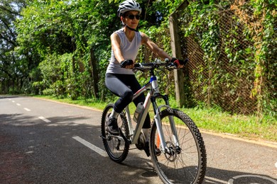 woman riding on bike path at park on sunny day