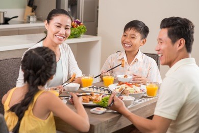 happy vietnamese family laughing while having dinner