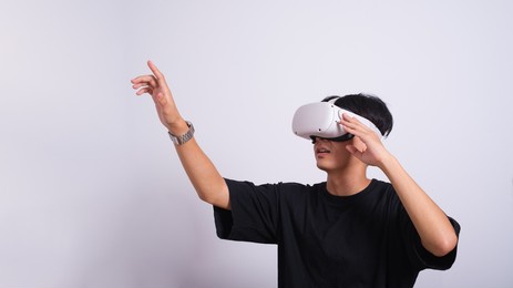 surprised teen male student use vr glasses and looks at empty copy space .virtual gadgets for entertainment, work, free time and study. virtual reality metaverse technology concept.